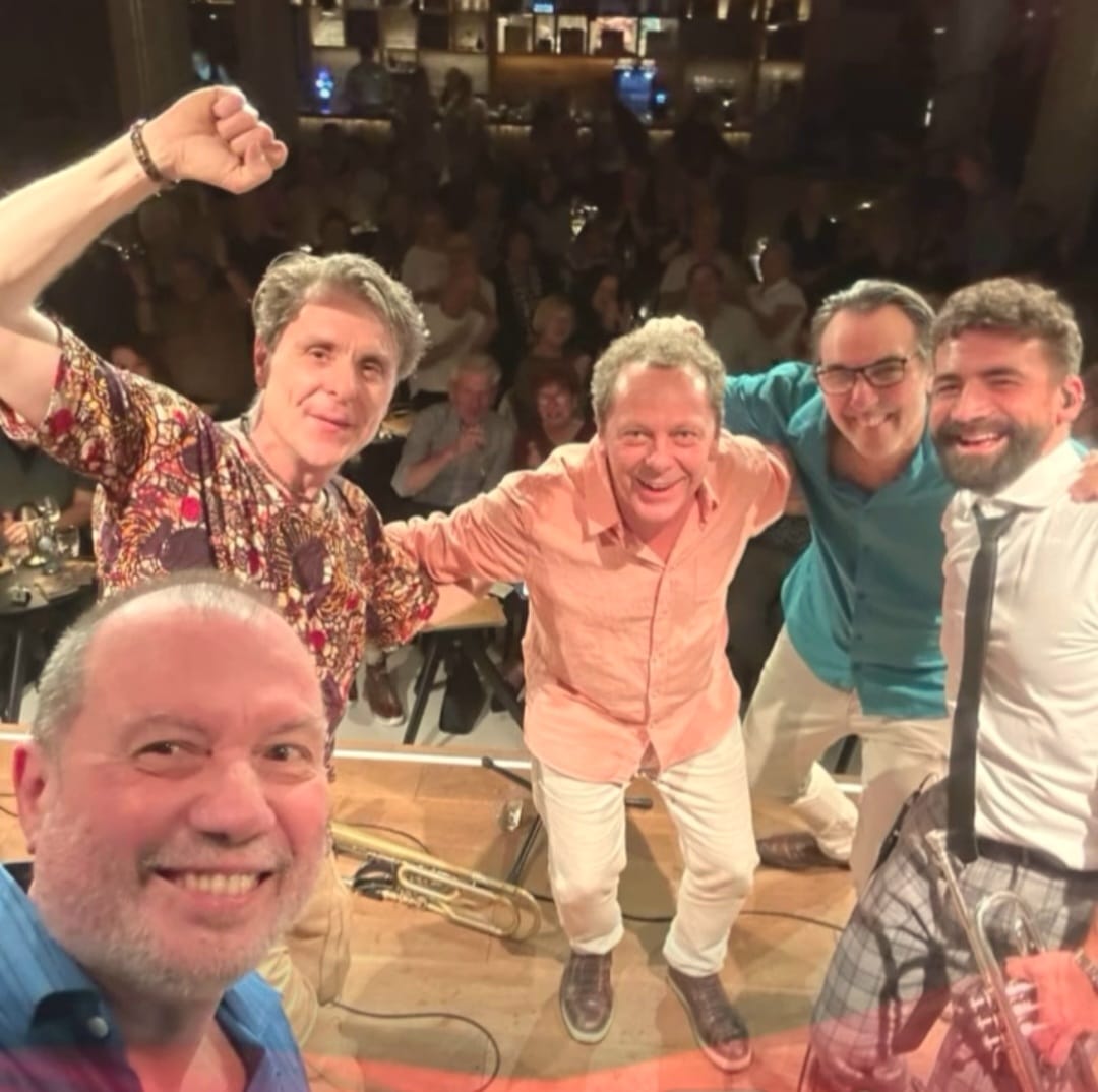 Jambo Trio e convidados no palco celebrando com a plateia ao fundo